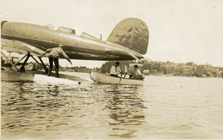 Charles and Anne Morrow Lindbergh row toward the Sirius to board, with a helping hand from Joe Burke of North Haven. The couple charted and flew the great circle route to China, a course still followed by airliners. PHOTO: COURTESY NORTH HAVEN HISTORICAL SOCIETY