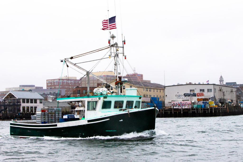 A lobster boat cruises past some of Portland’s wharves in late fall. PHOTO: JACK SULLIVAN