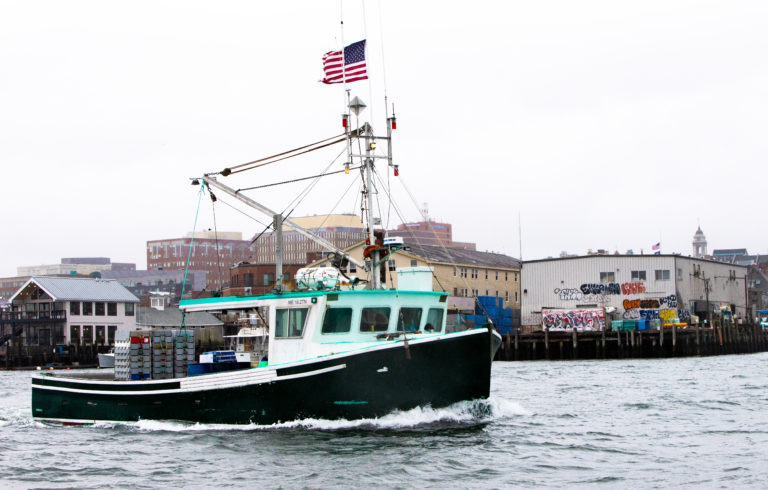 A lobster boat cruises past some of Portland’s wharves in late fall. PHOTO: JACK SULLIVAN