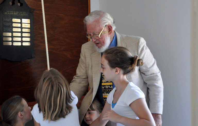 Ted Hoskins, who served for many years as minister on Isle au Haut, supervises children ringing the church bell. PHOTO: COURTESY PAUL LEWIS