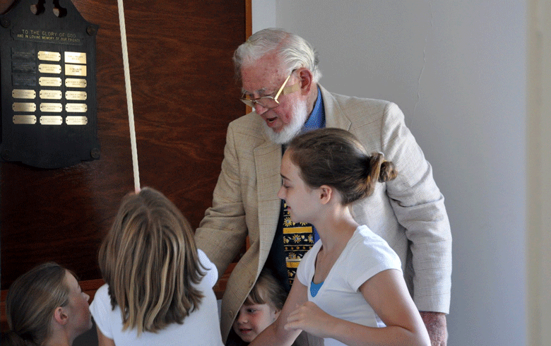 Ted Hoskins, who served for many years as minister on Isle au Haut, supervises children ringing the church bell. PHOTO: COURTESY PAUL LEWIS