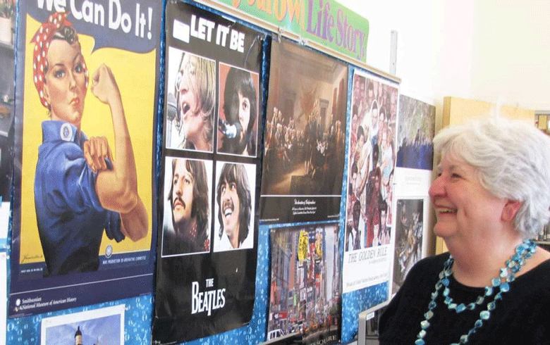 Donna Damon poses in front of a bulletin board in her classroom just before she retired. FILE PHOTO: TOM GROENINGa