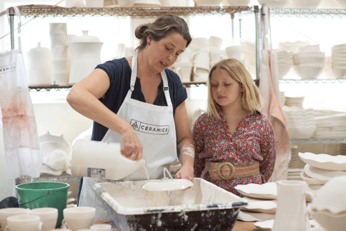 Alison Evans works as her daughter looks on. PHOTO: MICHELE STAPLETON