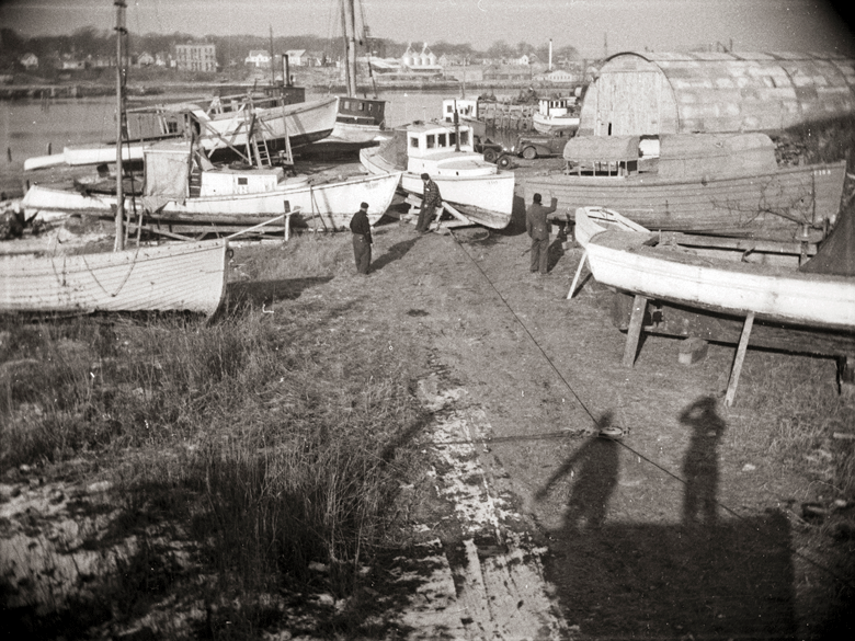 The shadows of two boys whose futures lay in the marine industry are visible in this photo, circa 1948, along with a lobster boat being dragged to its winter home at Snow Marine Basin. PHOTO: PENOBSCOT MAINE MUSEUM COLLECTION