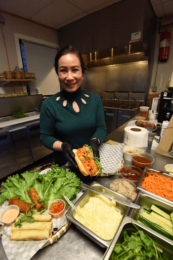 Hoa Le prepares a sandwich.