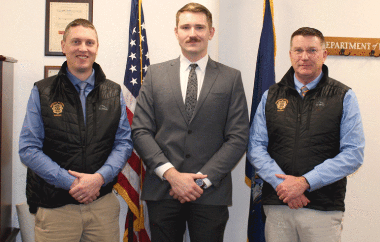 New Maine Marine Patrol Officer Ben Wiant, center, with Col. Matthew Talbot, left, and Department of Marine Resources Commissioner Patrick Keliher.