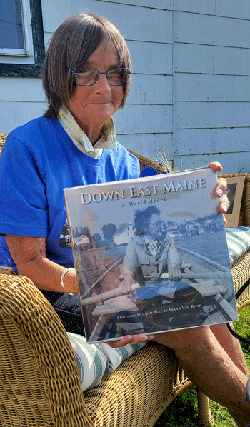 Delia-Mae-Farris-holding-book-with-photo-of-her-mother-Ruth-Farris.-Ruth-was-raised-at-Little-River-Light-in-Cutler