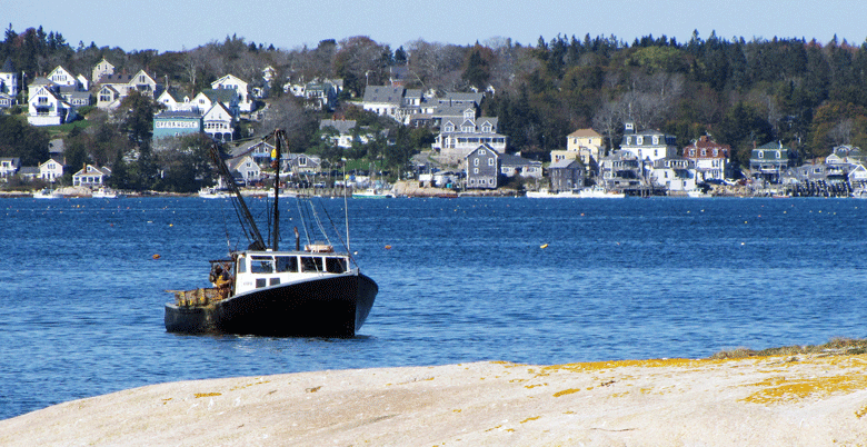 A fishing boat hauls traps with Stonington in the background. FILE PHOTO: TOM GROENING