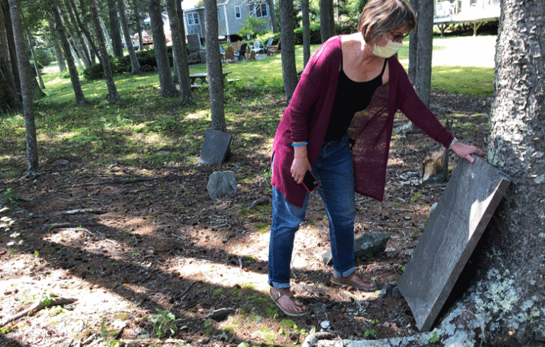 Lanette Sigel inspects one of the intact gravestones. PHOTO: TOM GROENING