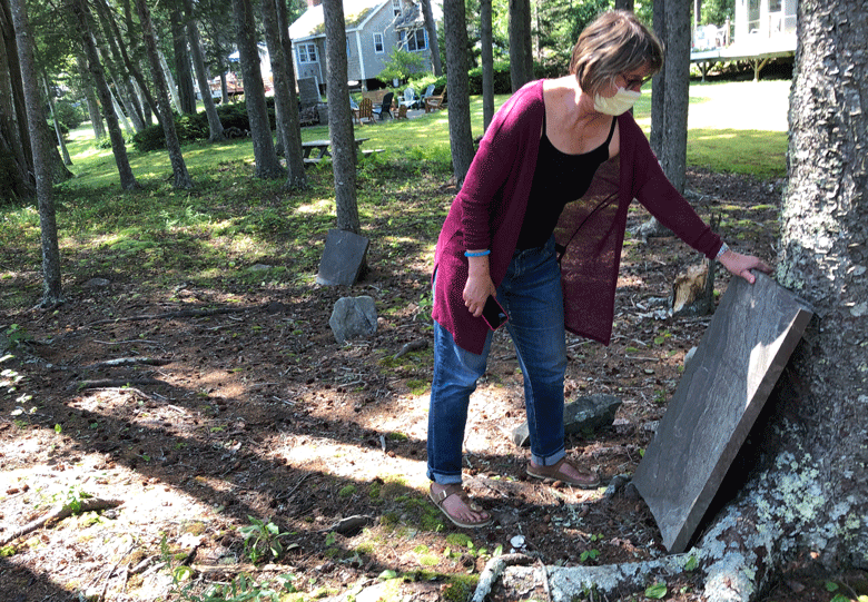 Lanette Sigel inspects one of the intact gravestones. PHOTO: TOM GROENING