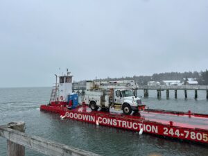 Versant truck arrives on a barge to restore power in Great Cranberry