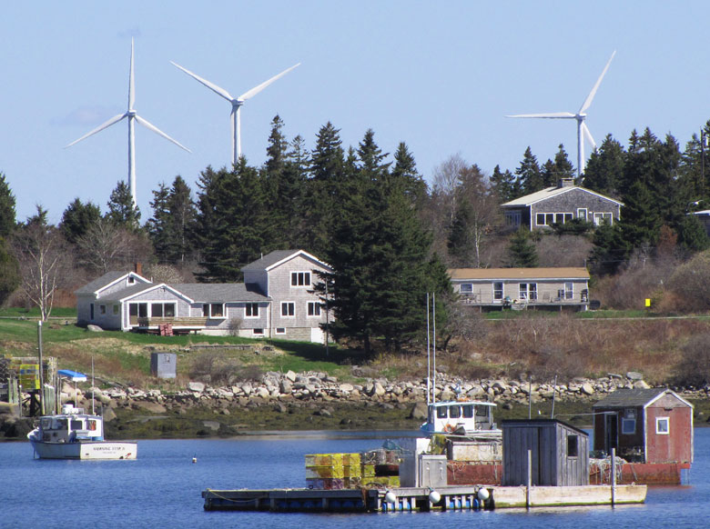 The Fox Island Wind turbines, located on Vinalhaven, appear closer to the shore than they actually are in this image, shot with a telephoto lens. FILE PHOTO: TOM GROENING