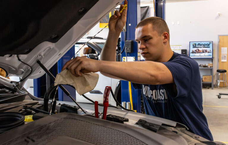 Knasic Byer checks fluid on a truck in the automotive shop.
