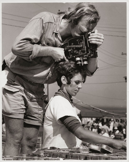 Rita Willey at work during a sardine-packing contest, a TV camera poised just over her head.